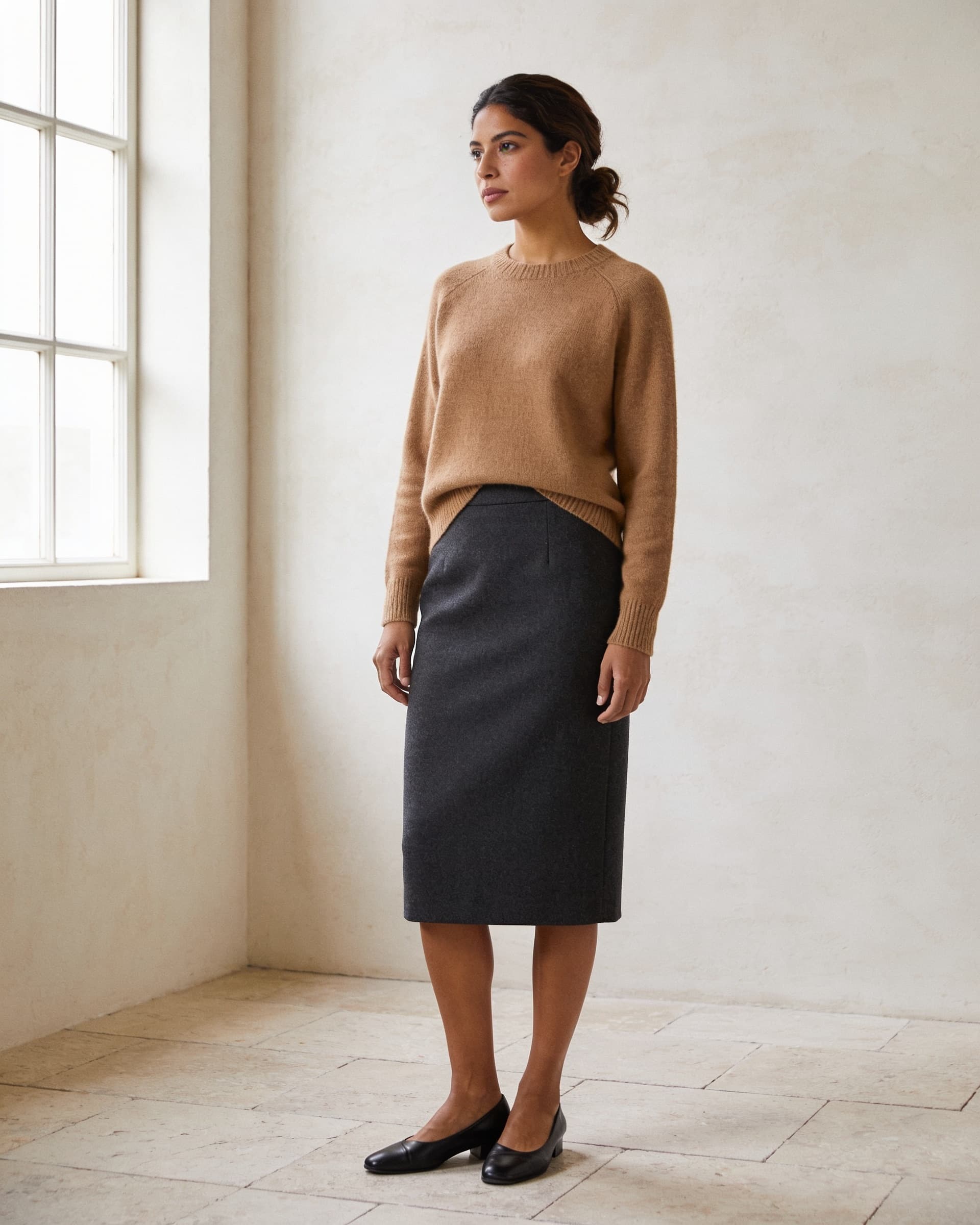 Mujer con falda lápiz de lana charcoal y suéter de punto camel